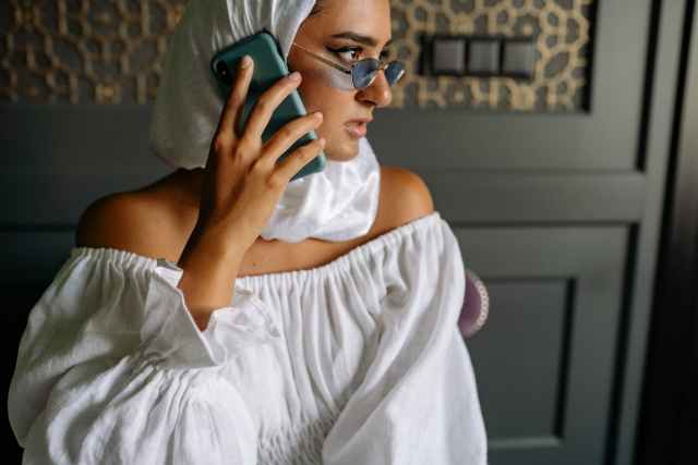 close up shot of a woman wearing white hijab while holding a cellphone