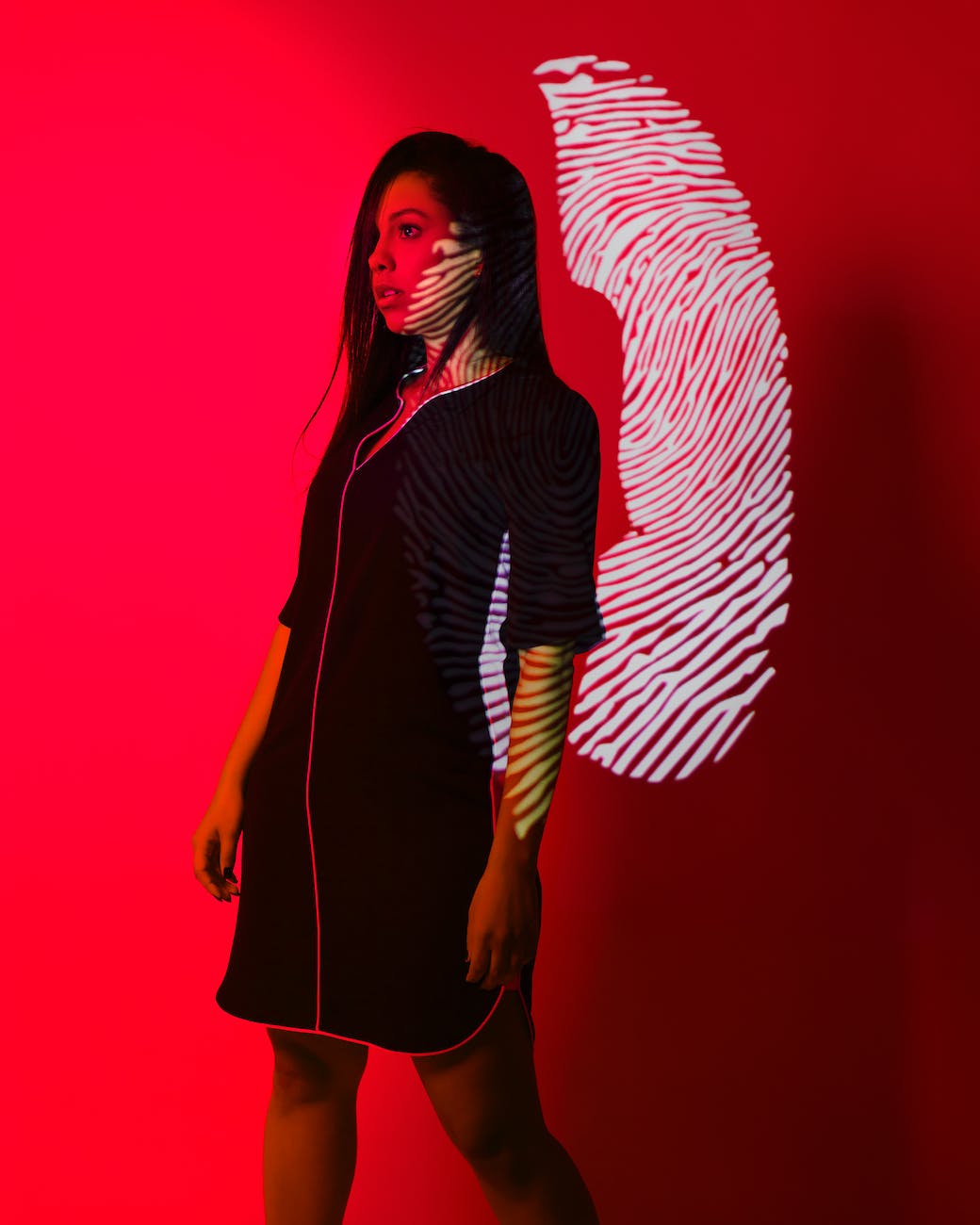woman with fingerprint reflection on red background